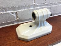View of vintage white ceramic sconce showing base and socket from a side angle
