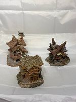 Three Boyd's Bearly-Built miniature village buildings displayed together on a white backdrop, showing detailed roofs and stone bases.