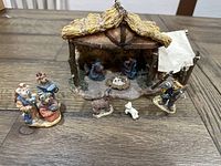 Nativity set showing the stable with figures of Mary, Joseph, baby Jesus, three additional bears, and sheep around it.