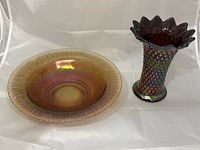 View of both the Norwood purple iridescent carnival glass vase and the West Moreland green iridescent carnival glass bowl side by side on white background.