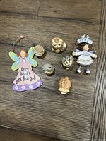 Seven Potbellies cat and angel figurines arranged on wooden floor: five cats and two angels.