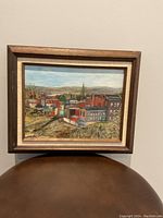 Front view of the framed oil painting showing the urban museum scene and landscape.