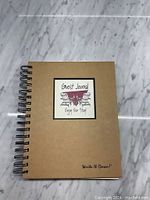 Front cover of the guest journal showing brown kraft paper and spiral binding with decorative label.