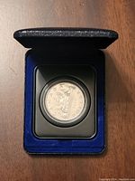 Open blue velvet Royal Canadian Mint box showing 1975 Canadian $1 Voyageur coin.