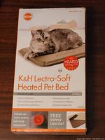 Box front of K&H Lectro-Soft Heated Pet Bed featuring a cat on the bed, indicating 20 watt heating, indoor/outdoor use, and thermally controlled warmth.