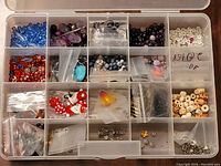 Organizer box showing various beads and jewelry crafting pieces sorted in compartments