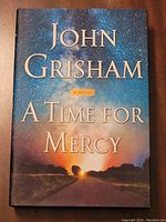 Front cover of the hardcover book 'A Time for Mercy' by John Grisham, showing the title and author name with a dramatic sky background.