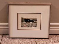 Framed print of a Quebecois house titled Maison D'Isle, showing the artwork, mat, and silver frame.