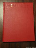 Front cover of the red hardcover Montreal 1976 Olympics book with gold embossed text and Olympic emblem.