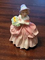 Front view showing detailed bonnet, facial features, dress and flower basket