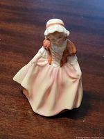 Front view of figurine showing detailed painted dress and bonnet