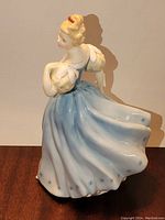 Side view showing the flowing blue and white gown with star accents and puffed sleeves.