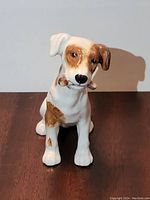 Front view of the Royal Doulton Jack Russell figurine showing the face and toy in mouth, with painted brown and white details.