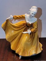 Front view of Royal Doulton Kirtsy HN 2381 porcelain figurine showing detailed facial features and flowing yellow dress.