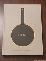 Front cover of the NOPI cookbook showing the frying pan graphic and author names.