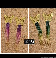Photo showing two pairs of handmade butterfly earrings with long beaded tassels; one pair with purple, pink, and gold beads, the other with green and gold beads.