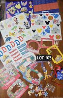 Wide view of all Disneyland scrapbooking items spread out, showing stickers, papers, frames, embellishments, and buttons.