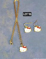 Photo showing the Hello Kitty jewelry set including a gold-tone necklace with Hello Kitty face pendant and matching earrings with the same pendants.