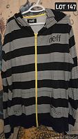 Front view of men's lightweight hoodie in black and white stripes with yellow zipper, size XL