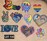 Top-down photo showing all 10 colorful hippie-themed embroidered patches arranged on a patterned fabric background.