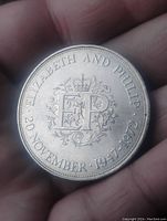 Photo of coin reverse with 'Elizabeth and Philip' inscription, crown, floral design, and dates.
