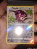 Close-up view of the Rattata Pokemon card showing reverse holo foil effect with star pattern and colorful artwork.