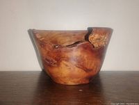 Front view of a hand-turned wooden burl bowl with visible natural burl wood patterns and live edge on the rim.
