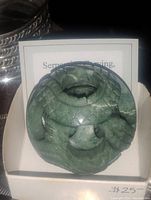Front view of green serpentine dragon ball carving displayed against a card with price tag $25.