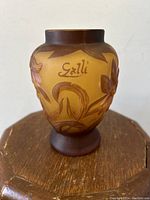 Photo showing front side of the small cameo glass vase with floral design and visible Galle signature.