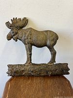 Front view of the cast-iron moose wall bracket with four hooks visible attached to the log base.