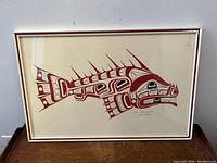 Frontal view of framed silkscreen print showing red formline fish design and pencil signature.