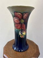 Front view of vase showing Clematis floral relief and color gradient.