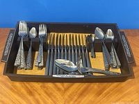 Overall view of 78-piece flatware set in fitted wooden tray