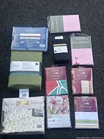 Photo shows 10 bed sheet packages laid out, including pink, green, floral, and multicolor patterned sheets. Brands Threshold, Royal Heritage, Eurotrend, Brass Gold, and Grand Essentials identified.