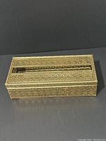 Top view showing detailed filigree metal design and slot in lid