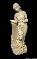Full view of the marble female statue leaning against a stone column base showing classical attire and missing parts on the arms