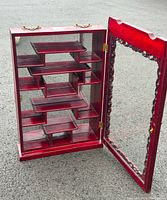 Open front view showing internal staggered wooden shelves and clear glass door with wood trim and brass hinges.