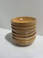 Stack of six vintage wooden bowls showing smooth light wood finish and round shape