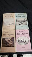 Four East Georgian Bay Historical Journal volumes displayed front cover up, showing illustrated and colored covers with titles and volume numbers.