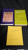Top view of three publications: two hardcover books and one yellow booklet related to Simcoe County history and postal services.