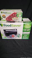 Photo of the unopened boxes: FoodSaver 3400 Series vacuum sealer box and box of 32 bags.