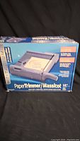 Box showing Paper Trimmer / Massicot branding and usage instructions.