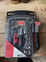 Front view of the 44 piece stubby tool and socket set in plastic case showing tools and sockets inside with red and black grips