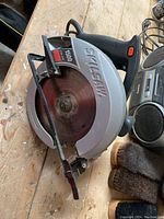 Full view of Skil circular saw on wooden surface, showing blade and handle.