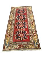 Full length photo of the Ardebil rug showing four medallions and multicolor borders on a red ground.