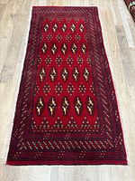 Image showing full rectangular Rug laid flat on wooden floor with visible traditional geometric pattern and fringed edges