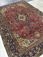 Full view of rug laid flat showing central medallion, field pattern, and borders
