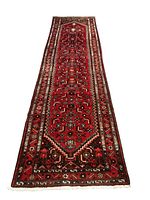 Full view of red runner rug with geometric pattern and fringe ends