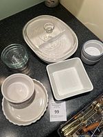 Overview of assorted clear and white ceramic kitchenware including Corning bakeware and ramekins