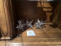 Photo of 5 vintage glass star-shaped candle holders on wooden furniture surface